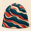 Teal rust and cream abstract beanie on a cream studio background