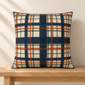 Cream plaid pillow styled on an oak bench