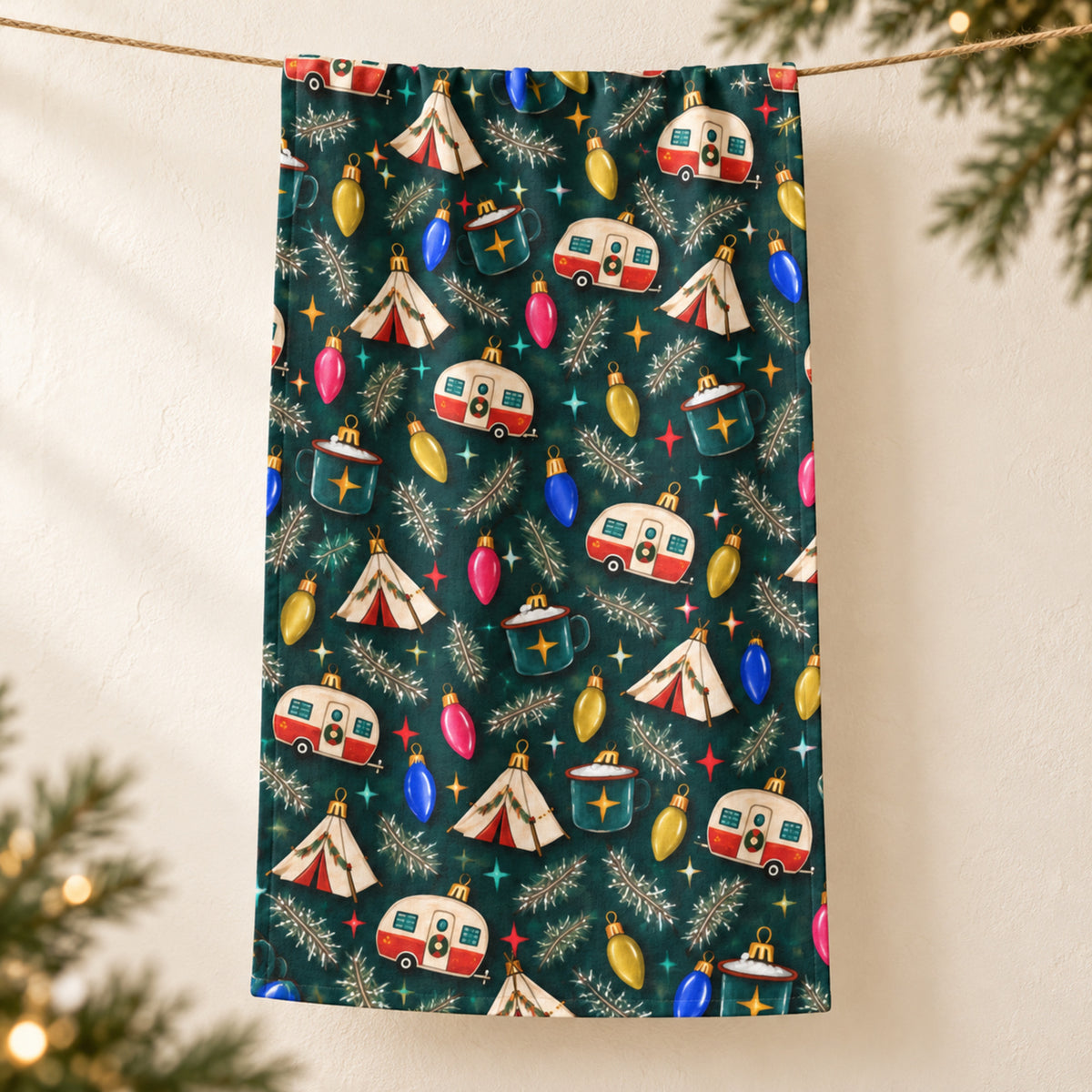 Retro Camp Christmas tea towel hanging over string against cream background with evergreen