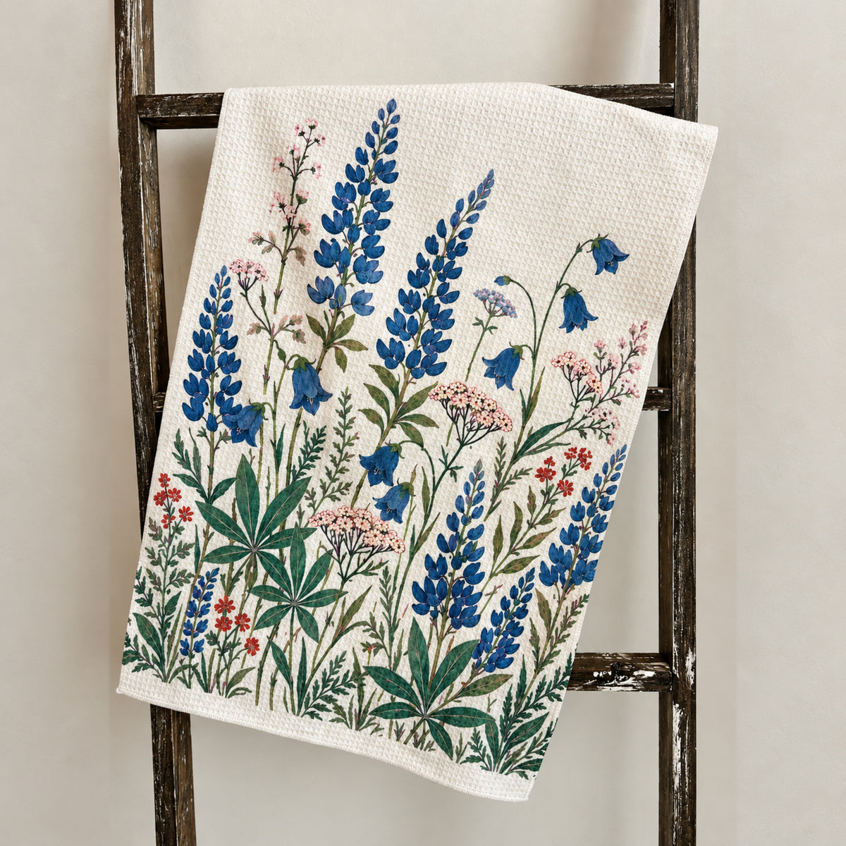 Lupine and bellflower tea towel draped over a rustic wooden ladder