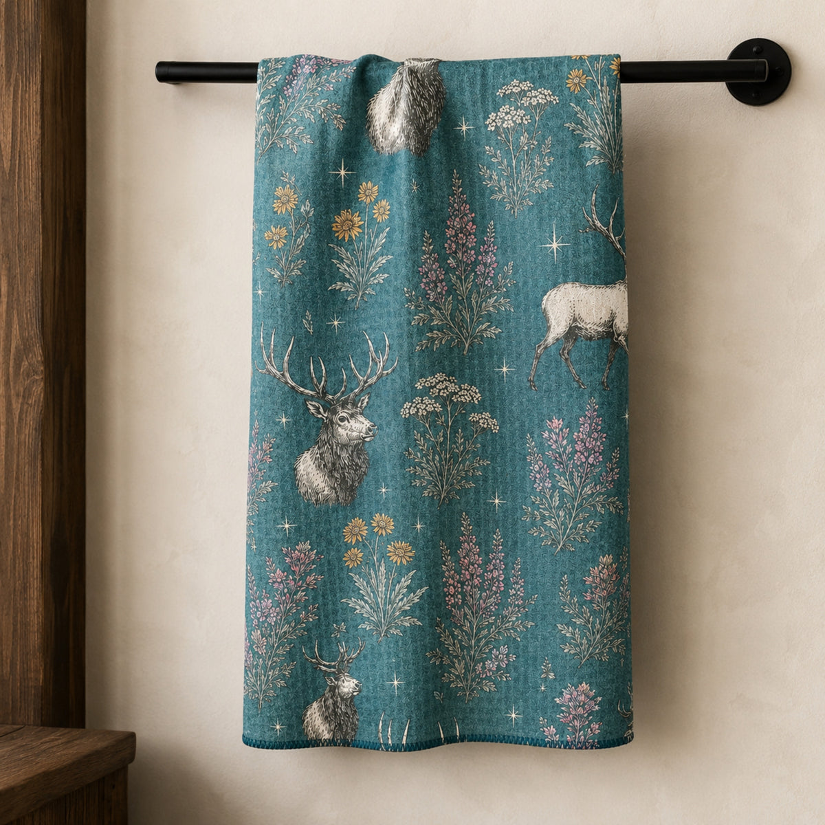 Elk and Wildflower tea towel hanging from a black towel rail