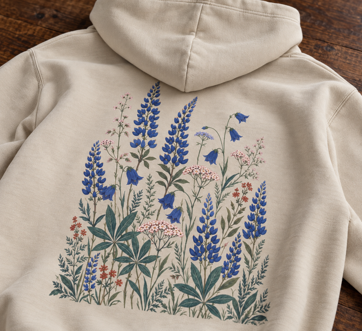 Close-up of blue lupine, bluebell and blush yarrow back print on sand hoodie