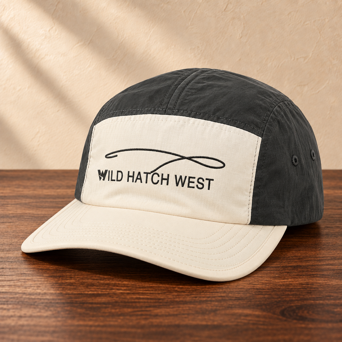 Finn Two-Tone Nylon Cap, angled studio view on dark wood against a cream wall